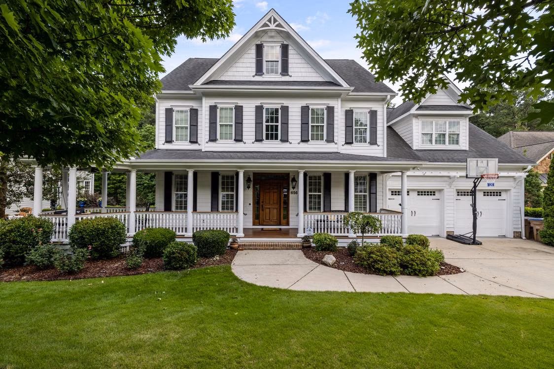 Porch-front home with white siding, a gray roof and a landscaped yard